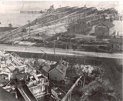 Work goes on after collapse of Phoenix processing plant, which killed six men in 1906.  Rails carried carts, filled with sand, to waiting barges in Hempstead Harbor, N.Y.