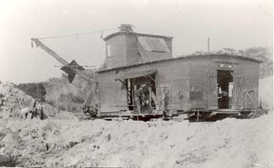 Laborers dig out sand by hand and load it into shovel, c. 1910