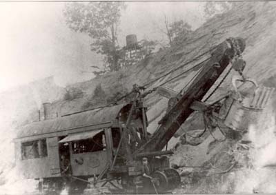 Old steam shovel, with basic 3-man crew of fireman, engineer, craner and pitman in front, c. 1920