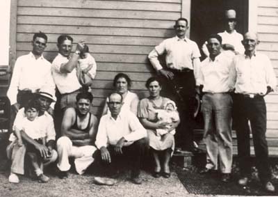 Sardinian sandminers and their families in front of barrack housing provided by sandmining company, 1934 L-r top: Tony Maria Carta, John Dettori holding little Eleanore Canale, Giovannantonio Scanno, Tony (?) L-r bottom: John Pedranghelu, Gavino Piccizzolo, Joe Falque, Giovanni Canale, Eleanore Canale, Giovanna M. Grommja Salvi, Santina Frommja Salvi, Gavino Deddola, Zio Cristophelo (?) 