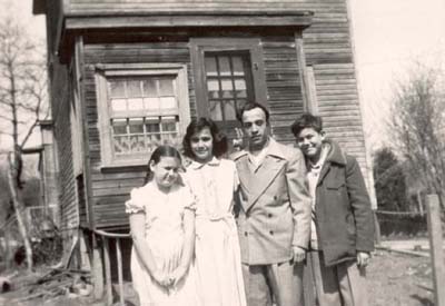 Nancy Deriu Palens family in front of home in sandbanks, c. 1951