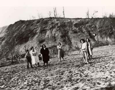 Nancy Deriu Palen plays baseball in sandbanks near her home, 1950�s