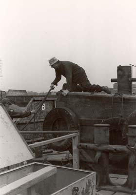 Mr. Farina, loader, putting rope on bit to secure barge