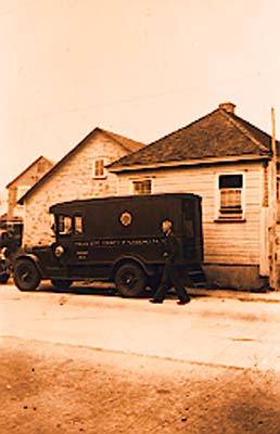 Police truck at sand company office, 1938