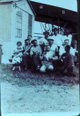 Sandminers play hand game, �mura�, while family members look on, c. 1930